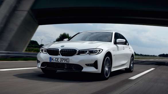 Plug-in hybrid BMW 3 Series Sedan 2021 G20 three-quarter front view driving Plug-in hybrid BMW 3 Series Sedan 2021 G20 three-quarter front view driving on the street