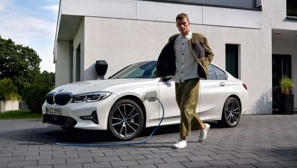 Plug-in hybrid BMW 3 Series Sedan 2021 G20 three-quarter front view charging Plug-in hybrid BMW 3 Series Sedan 2021 G20 three-quarter front view charging with model