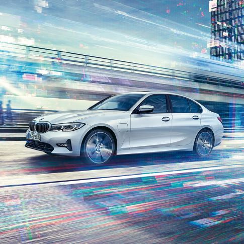 BMW 3 Series Sedan, side view of the driving BMW 3 Series Sedan 330e. Side view of the driving BMW 3 Series Sedan 330e in front of urban backround.