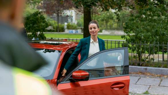 BMW Roadside Assistance. BMW Roadside Assistance woman standing in the open door of her BMW