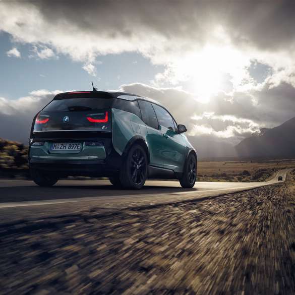 BMW i3 2018 three-quarter rear view driving on highway BMW i3 I01 2018 Jucaro beige with Frozen Grey metallic highlight three-quarter rear view driving on highway