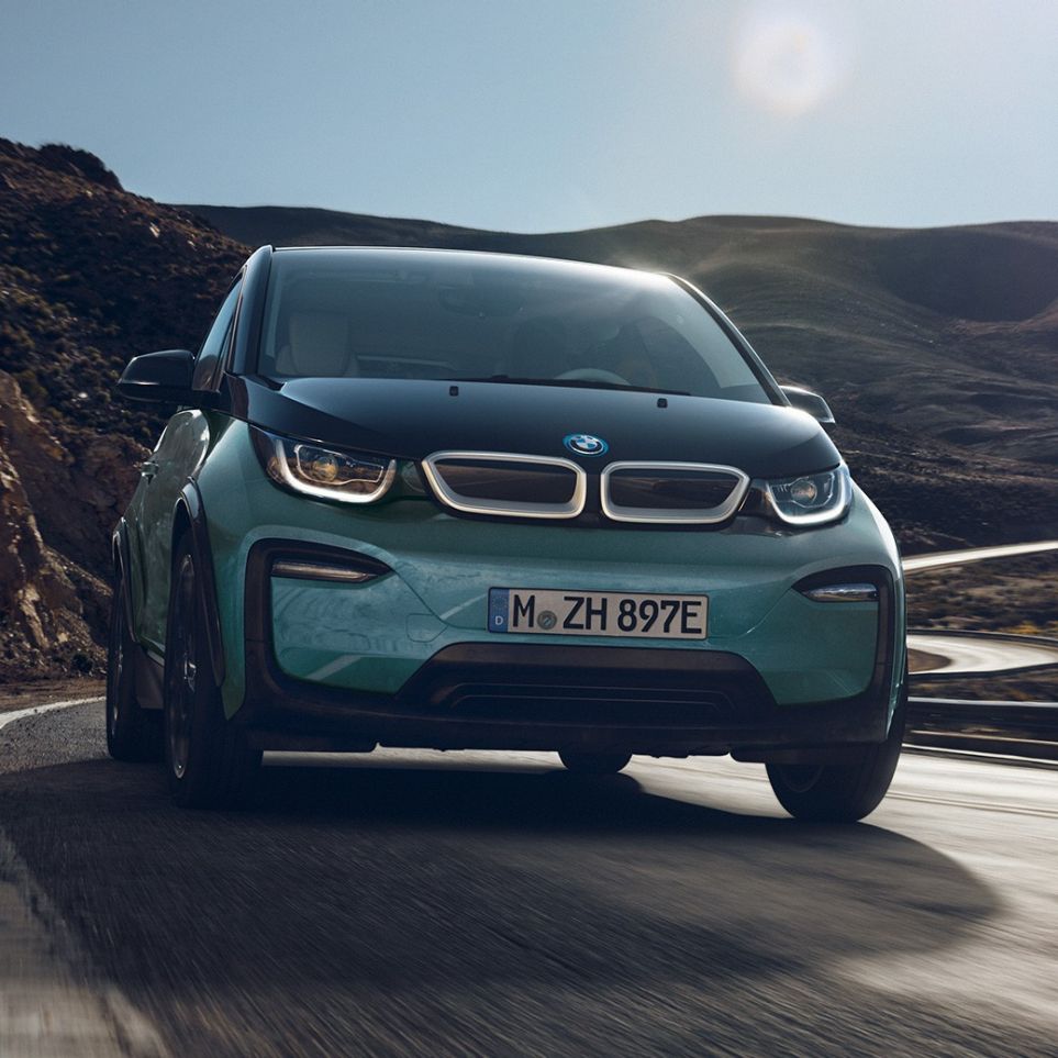 BMW i3 2018 side view driving BMW i3 I01 2018 Jucaro beige with Frozen Grey metallic highlight side view driving in urban setting