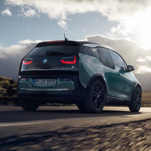 BMW i3 2018 three-quarter rear view driving on highway BMW i3 I01 2018 Jucaro beige with Frozen Grey metallic highlight three-quarter rear view driving on highway
