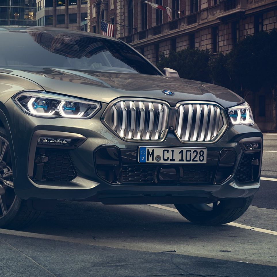BMW X6 M50i standing. BMW X6 M50i in three-quarter front perspective standing in front of an urban setting.