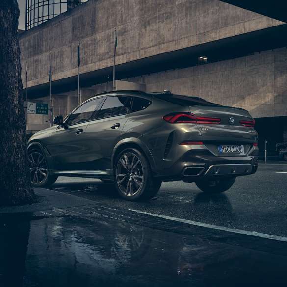 BMW X6 exterior. BMW X6 in three-quarter rear perspective in front of an urban setting.