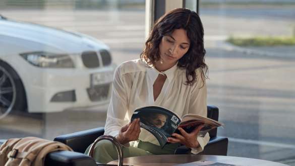 BMW Dealer Warranty BMW Repair and Care BMW Dealer Warranty BMW Repair and Care woman seated with BMW catalogue in her hand