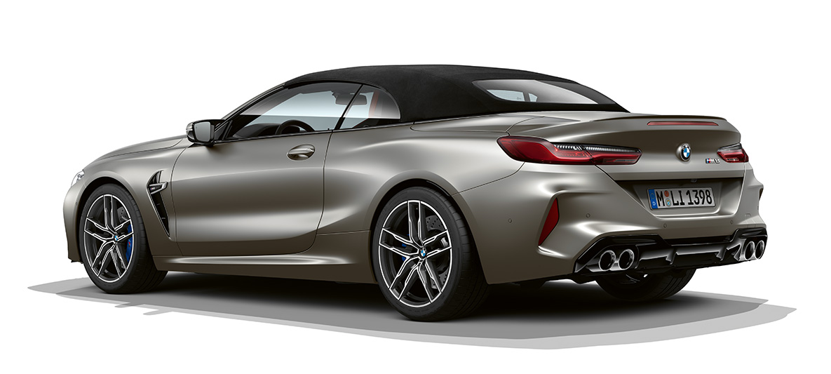 BMW M8 Convertible, three-quarter side view rear. BMW M8 Convertible in Frozen Dark Silver, three-quarter side view from rear.