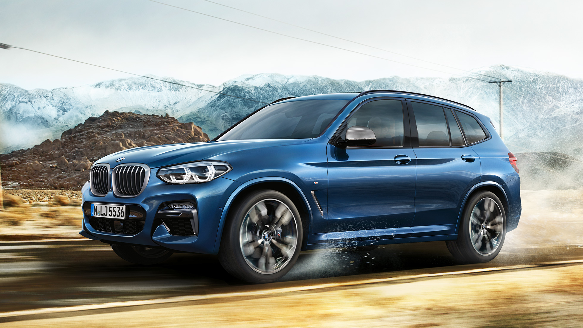 BMW X3 M40i, medium shot rim and front fender in front of mountain BMW X3 M40i, medium shot rim and front fender in front of mountain