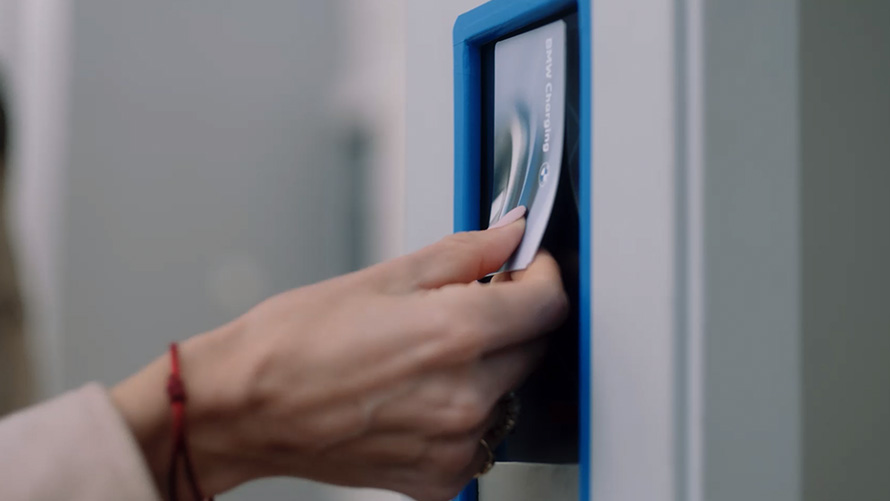 Person placing BMW Charging Card at public charging station